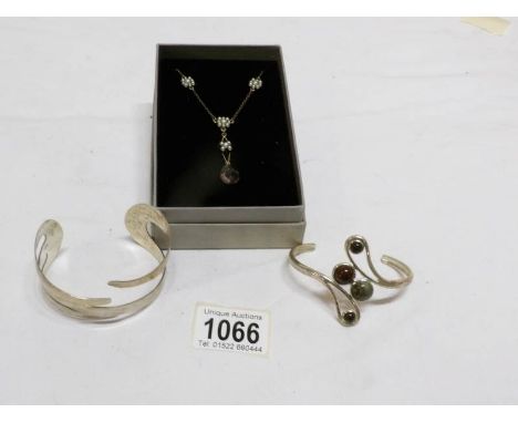A silver bangle, stone set bangle and a necklace