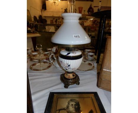 A Victorian oil lamp with ceramic base and complete with shade and chimney