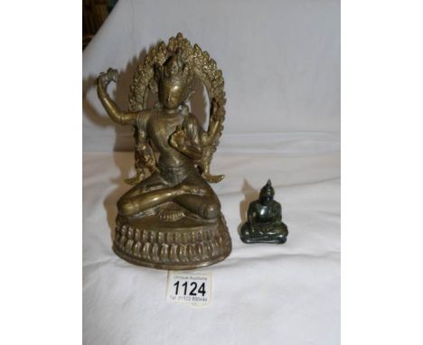 A brass Ganesha figure and a green jade Buddha