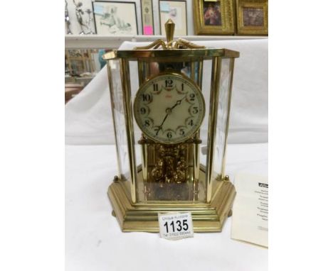 A brass cased Kundo anniversary clock with instructions