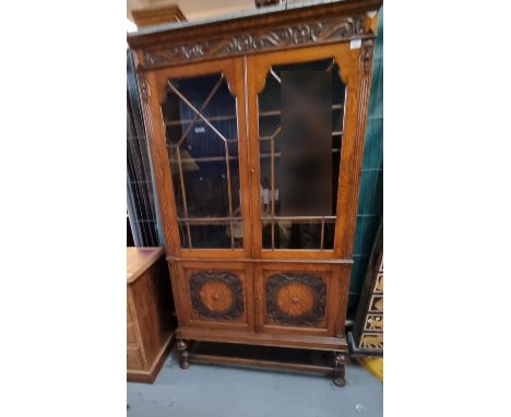 Early 20th oak two door glazed bookcase with two panel doors below on cup and cover supports.  105cm wide approx.(B.P. 21% + 