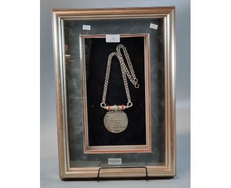 Omani silver pendant necklace with suspension chain, the circular pendant with Islamic script.  Framed and glazed.  (B.P. 21%