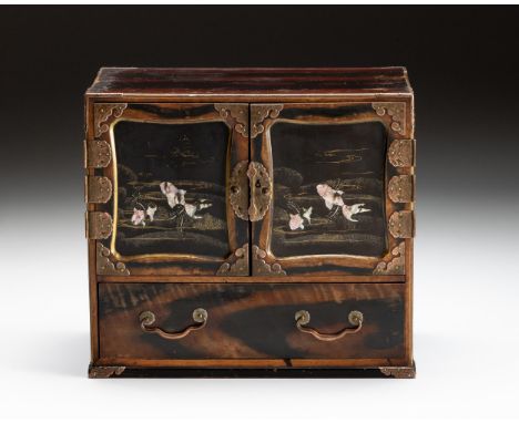 Rectangular, the exterior skillfully painted to resemble persimmon wood, the panelled doors inlaid with mother-of-pearl ornam