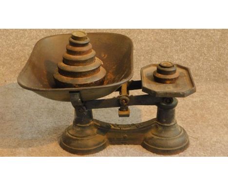 A vintage set of green painted iron grocers scales with its set of weights. 20x36cm 