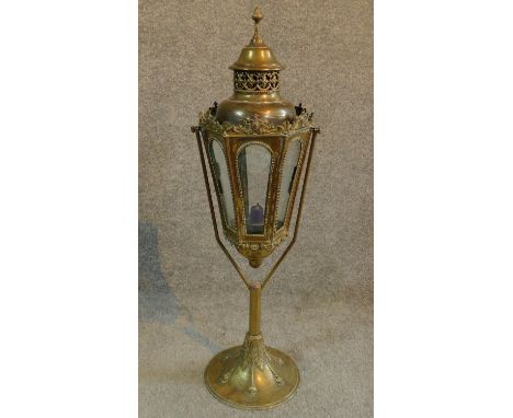 A swinging antique brass arts and crafts table lamp/candle holder with intricate brass detailing and piecework. H.67cm 