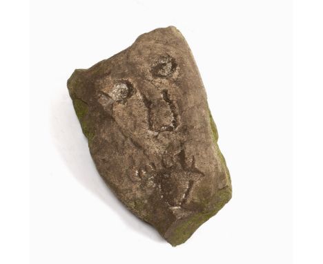 A ROUGH HEWN STONE CORBEL with carved image of a human face, approx. 30 x 19cm