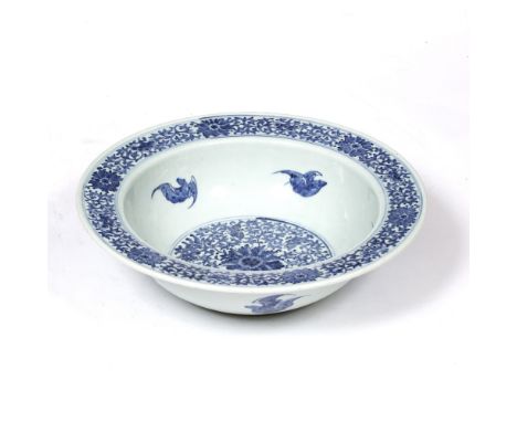 A CHINESE BLUE AND WHITE BASIN, with florally decorated centre and wide rim, painted with bats in flight, 39.5cm in diameter