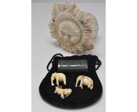 A reindeer antler carving, two early 20th century elephant charms, another of a dog and a carved jade pendant