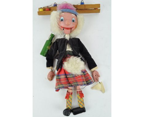 A Pelham Scotsman puppet, dressed in a kilt and holding a bottle, 31cm high