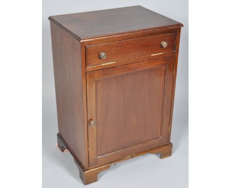 A mahogany side cabinet with one vertical hinged cupboard above a panelled door on bracket feet, 78cm high x 53cm wide x 38.5