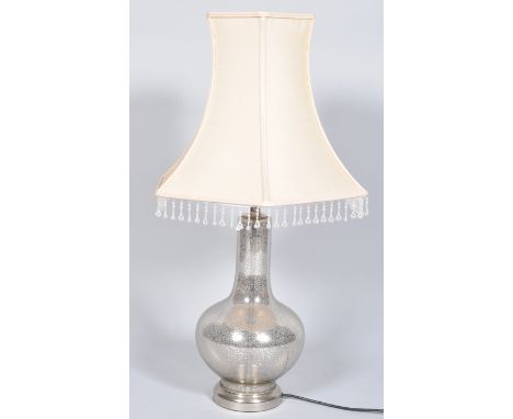 A contemporary glass lamp base having a translucent mottled silver pattern raised on a plinth base, along with a shade atop w