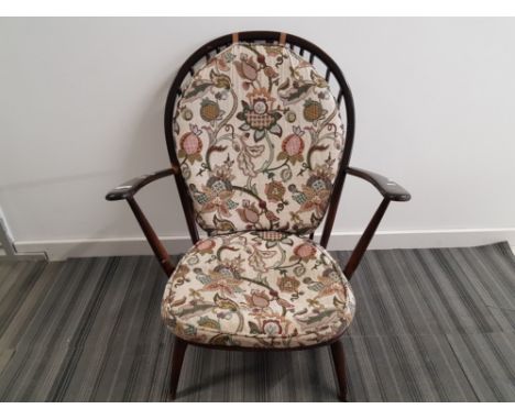 An Ercol style stained wood open armchair.