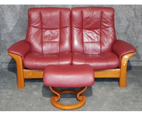 A Stressless red leather Windsor highback two seater sofa, and an Ekornes Stressless pouffe.