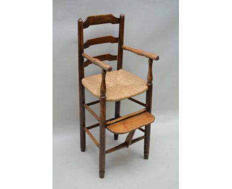 A 19TH CENTURY LADDER BACKED CHILD'S HIGH ARMCHAIR, with rush work seat, complete with footrest, 53cm to seat height, 89cm hi