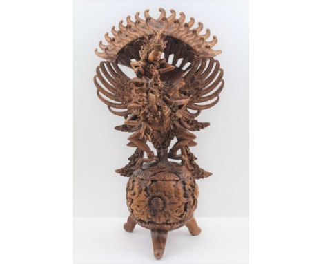 A 20TH CENTURY BALINESE WOOD CARVING, Vishnu riding the mythical Garuda bird, standing upon a floral and acanthus scroll carv