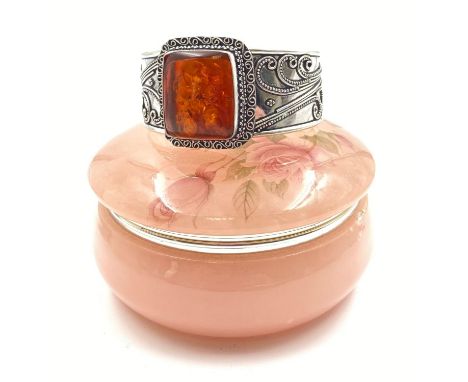 A very attractive, sterling silver (stamped 925), ornate bangle with a large amber central stone 4 cm wide. Presented in pink