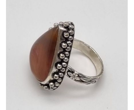 A large pear shaped statement ring in silver featuring a coffee coloured stone. Size R. 