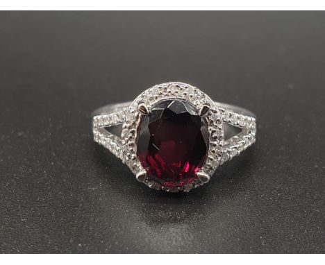 An 18K White Gold Diamond and Garnet Ring. Size P.3.14g 