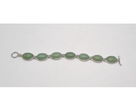 A stylish pale green jade stoned bracelet on white metal. 19cm in length, each stone 18mm each. 