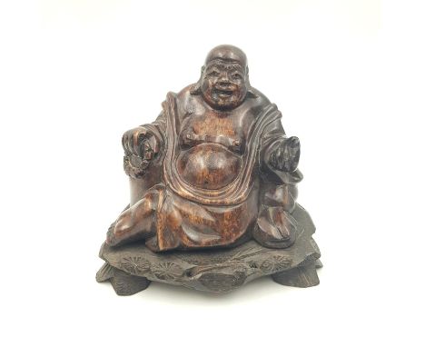 A late 19th Century, Chinese, hand carved, hard stone, smiling Buddha statue, on a wooden base, with lotus flowers ornamentat