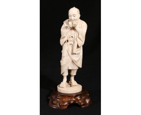 Japanese carved ivory model of a standing male figure, carved wooden stand, Meiji/Taisho, 20cm