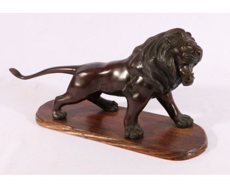 Japanese bronze model of a lion with inset glass eyes, wooden base, signed to base, 45cm.