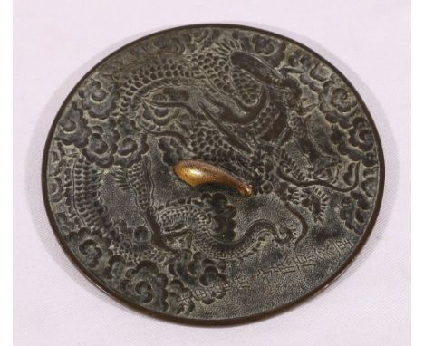 Fine quality small bronze hand mirror, decorated in sharp relief with a dragon amongst clouds, a gilded punched bronze handle