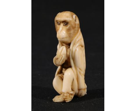 Carved Japanese ivory netsuke of a seated monkey wearing traditional clothes holding a peach, 5.5cm, Meiji