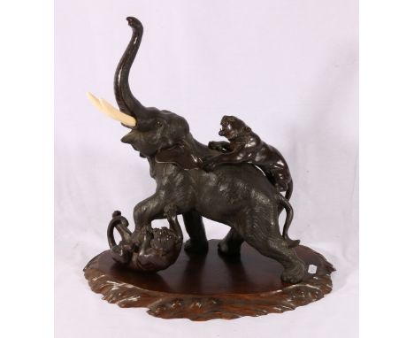 Japanese late 19th or early 20th century bronze model of an elephant being attacked by two tigers, carved wooden base, Meiji/