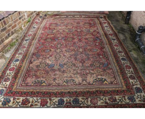 Zeigler style carpet with all-over floral design, over deep red ground group border (worn), 366cm x 247cm. CONDITION REPORT: 