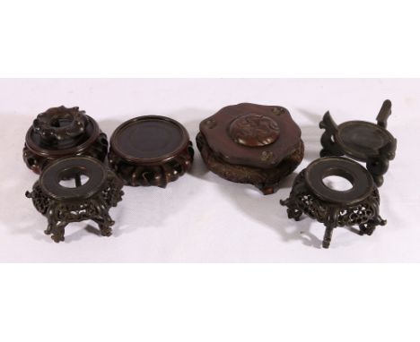 Group of seven Chinese hardwood stands and a lid, to include a pair raised on scroll supports with pierced and carved aprons,