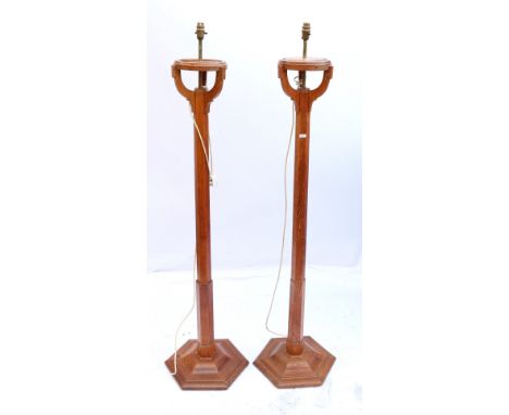 Pair of oak torchere standard lamps each with circular top raised on hexagonal columns on tripod base, 140cm high