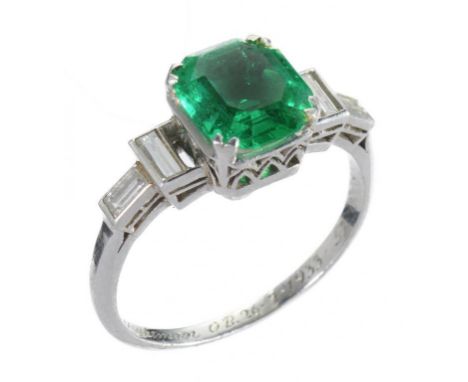 AN ART DECO EMERALD AND DIAMOND RING, C1930  the step cut emerald approx 0.6 x 0.6cm, in platinum, hoop inscribed Dennis Conw