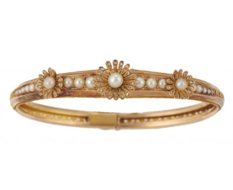 A FRENCH CULTURED PEARL AND GOLD ARTICULATED BANGLE, C1900  applied with three stylised flowerheads, 6cm, indistinct maker's 