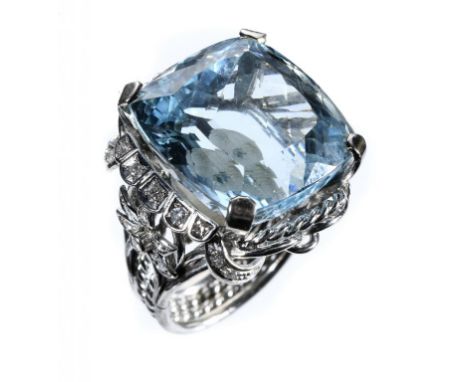 AN AQUAMARINE AND DIAMOND RING  with cushion shaped aquamarine of approx 18 x 19mm and wirework hoop with diamond set flower 