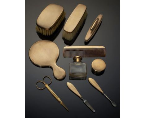 A GEORGE V 9CT GOLD BRUSH AND MANICURE SET  engine turned, hand mirror 13cm l, by William Neale Ltd, Birmingham 1927, fitted 