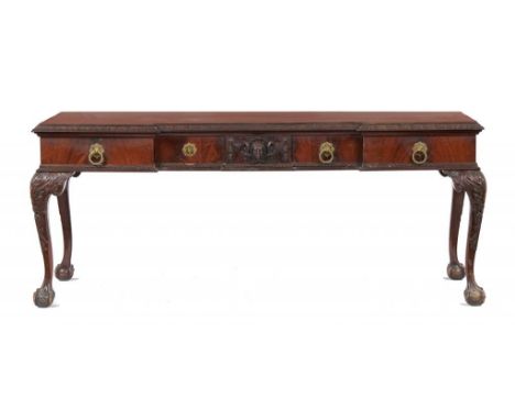 A CARVED MAHOGANY SERVING TABLE, EARLY 20TH C in George II style, the central drawer carved with a mask on leaf carved cabrio