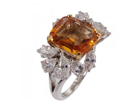 A TOPAZ AND DIAMOND RING the step cut topaz approximately 0.8 x 0.9cm between an asymmetrical arrangement of marquise and pea