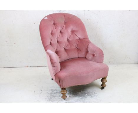 Victorian Pink Upholstered Button Back Armchair, raised on turned supports with castors, 66cm wide x 85cm high 