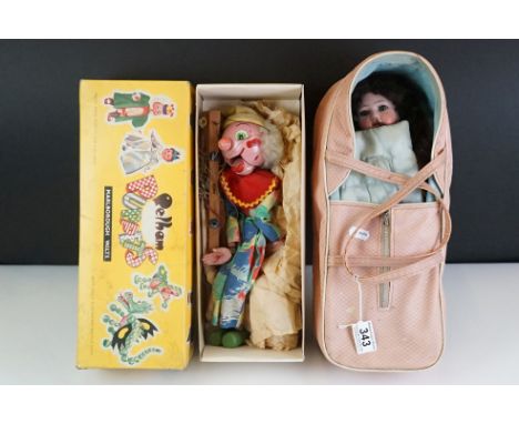 Bisque headed doll with sleeping eyes and painted face, indistinct markings to back of head, in a carrycot, together with a b