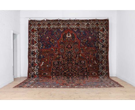 A large Bakhtiari wool carpet, Persian, the central field decorated with a large flower head medallion to a dark red and navy