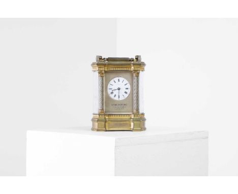 A large brass carriage clock, early 20th century, the white enamel dial marked by Roman and Arabic numerals, an engraved insc