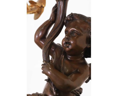 A pair of Louis XV-style gilt and patinated bronze candelabra, late 19th century, French, each modelled as a seated putto hol