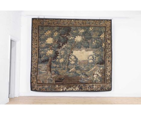 A verdure tapestry fragment,  17th century, Flemish, decorated with pheasants in a wood with a house beyond, within a foliate