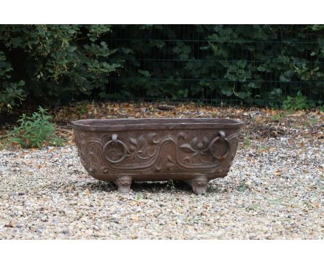 A Tang-style cast iron trough, 20th century, Chinese, cast with panels of flowers, hoop rings and dragon-head feet,105cm wide