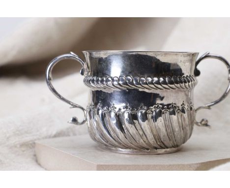 A silver-gilt porringer, London 1680-1697, the body with a gently flared rim over moulded band and twin 'S' scroll handles, t