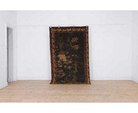 A verdure tapestry panel, 18th century, French, the central field decorated with a river landscape, figures in boats and a ho