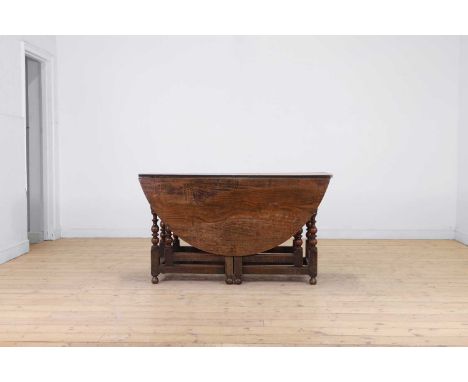 A Charles II oak drop-leaf table, late 17th century, the oval top above a pair of drawers and a double gateleg action, and bo
