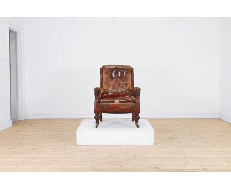 A William IV leather armchair, second quarter of the 19th century, with deep button upholstery, the arms carved with lion mas