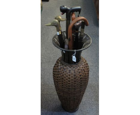 Cane bound metal vase shaped stick stand containing an assortment of walking sticks, various. (B.P. 24% incl. VAT)